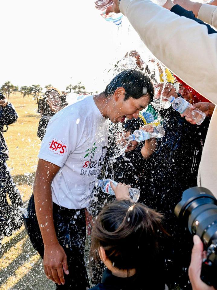 　通算１４アンダーで優勝し、祝福される鍋谷