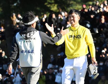 　優勝を決め、キャディーとハイタッチする蟬川泰果（撮影・伊藤笙子）