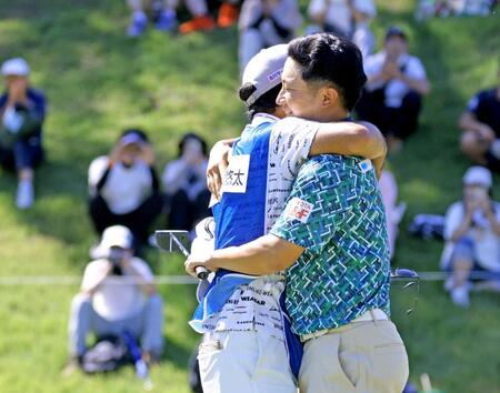 　優勝を決め、キャディーと抱き合って喜ぶ杉浦悠太