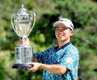 　通算１８アンダーで優勝し、トロフィーを手に笑顔を見せる杉浦悠太