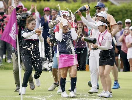 　最終ラウンド、通算１９アンダーで優勝し、山下美夢有（左端）らからシャンパンで祝福される古江彩佳（中央）＝１４日、フランス南東部エビアンのエビアン・リゾートＧＣ（共同）