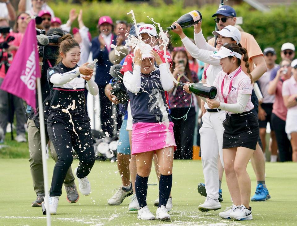 　通算19アンダーで優勝し、山下美夢有（左端）らからシャンパンで祝福される古江彩佳（中央）