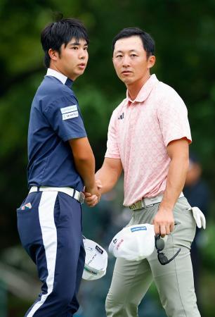 　第３日、通算１２アンダーで首位に並び、握手を交わす細野勇策（左）と岩崎亜久竜＝三好ＣＣ