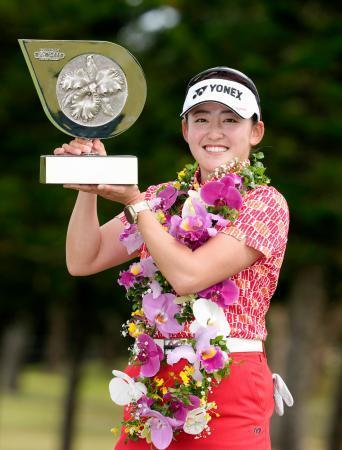 　通算１０アンダーで大会２連覇を果たし、トロフィーを手に笑顔の岩井千怜＝琉球ＧＣ