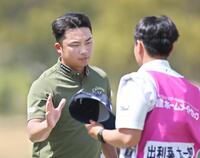 　ホールアウトし、キャディーと言葉を交わす出利葉太一郎