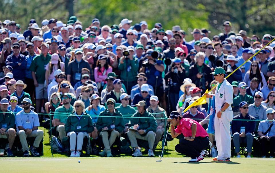 　２番でラインを読む松山英樹。通算３アンダーで１２位（共同）