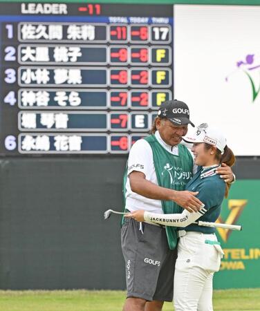 　通算１１アンダーで初優勝を果たし、キャディー（左）と喜ぶ佐久間朱莉