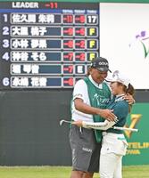 　通算１１アンダーで初優勝を果たし、キャディー（左）と喜ぶ佐久間朱莉