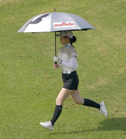 　傘を手に翔ぶようにフェアウェイを駆ける川崎春花（撮影・持木克友）