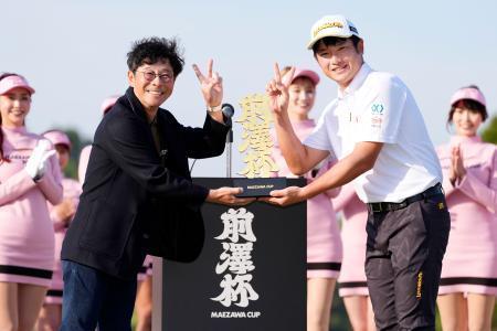 　ツアー初優勝を果たし、前沢友作氏（左）からトロフィーを受け取る小西たかのり＝ＭＺ・ＧＣ