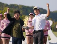 　大会主催者の前澤友作氏（左）から優勝トロフィーを受け取りガッツポーズを決める小西たかのり（撮影・開出牧）