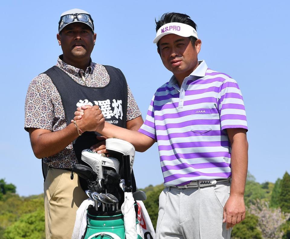 　最終日のラウンドを終えキャディーのプラサド・ラジーフさん（左）と握手を交わす池田勇太（撮影・開出牧）