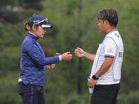 　１０アンダーの首位となり、キャディーとタッチを交わす藤田さいき（左）＝撮影・西岡正