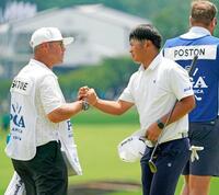 　ホールアウトしキャディー（左）と握手を交わす久常（共同）