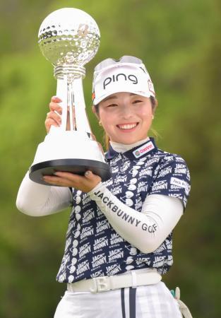 　通算２０アンダーで２勝目を挙げ、トロフィーを手に笑顔の佐久間朱莉＝中京ＧＣ石野