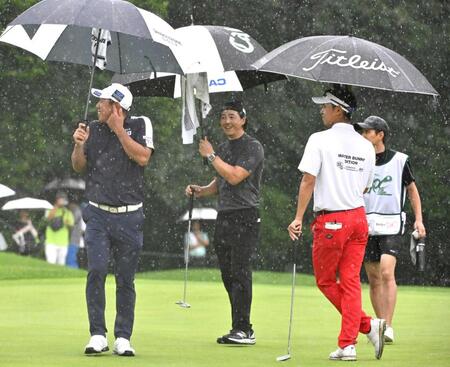 　８番グリーンで競技中断を告げるホーンの音に驚く堀川未来夢（左）と石川遼