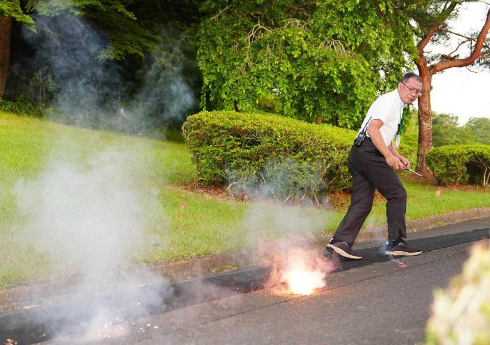 　試合前、コースでクマ対策の爆竹を鳴らす福士明嘉支配人
