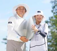 　通算２４アンダーで優勝した池村寛世。キャディーを務めた琴音さん（右）