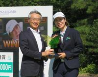 　明治安田・永島英器社長（左）から優勝盾を贈られる李知姫