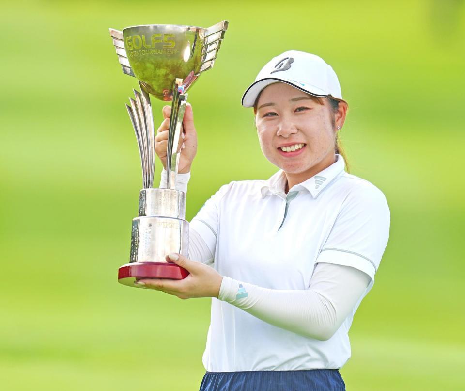 　ツアー初優勝を果たし、笑顔で優勝トロフィーを掲げる荒木優奈