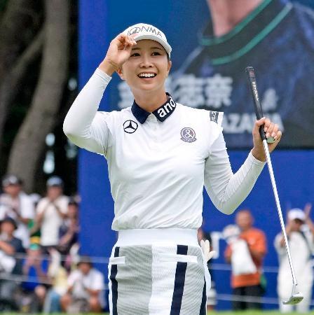 　最終日、ウイニングパットを沈めギャラリーの声援に応える金沢志奈。通算１０アンダーで優勝＝大洗ＧＣ