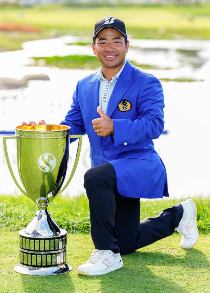 　通算１８アンダーで優勝し、トロフィーと写真に納まる比嘉一貴（共同）