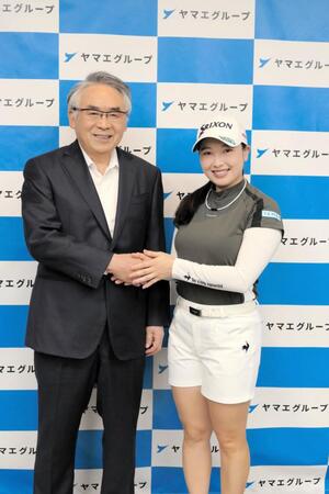 　網田日出人会長（左）と握手をする小祝さくら