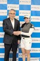 　網田日出人会長（左）と握手をする小祝さくら