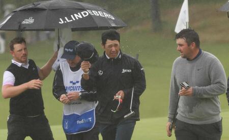 　雨の中、クラブハウスに向かう松山英樹（中央）＝横浜ＣＣ（撮影・佐々木彰尚）