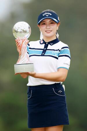 　通算１４アンダーで優勝し、トロフィーを手に笑顔を見せる河本結