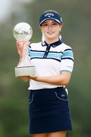 　通算１４アンダーで優勝し、トロフィーを手に笑顔を見せる河本結