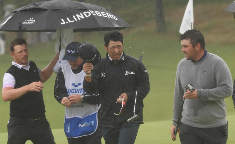 　雨の中、クラブハウスに向かう松山英樹（中央）＝横浜ＣＣ（撮影・佐々木彰尚）