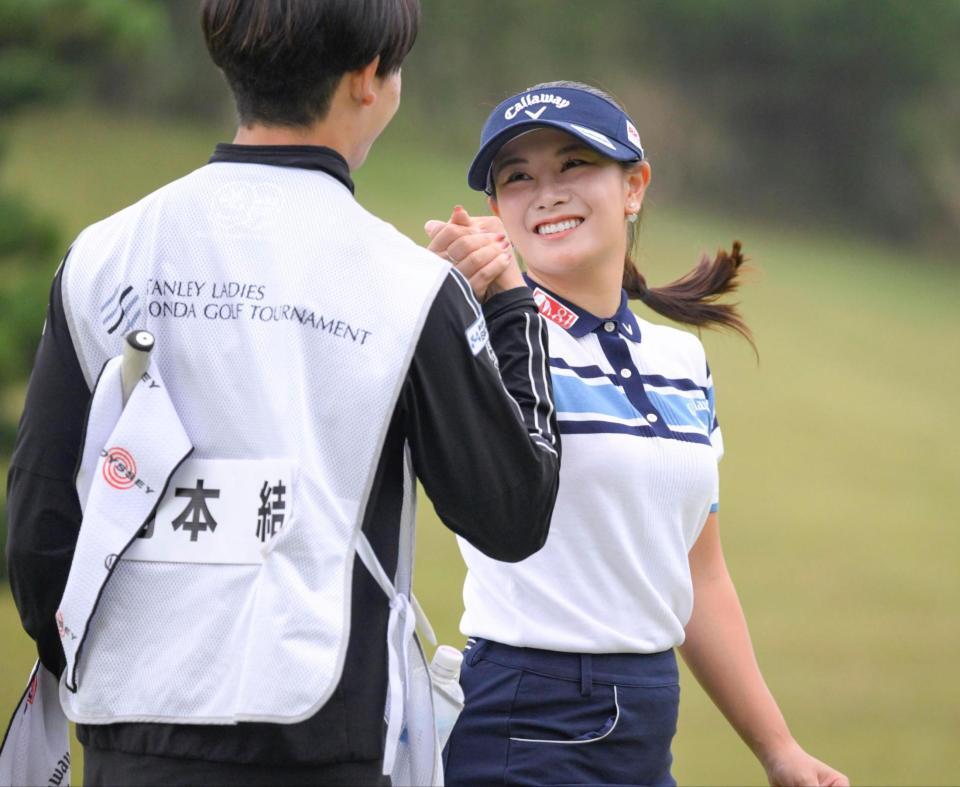 　優勝し、キャディーと笑顔で握手する河本結