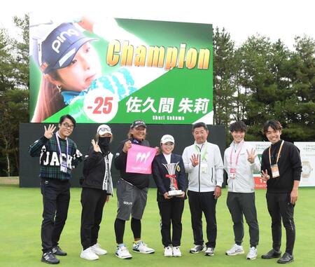 　通算２５アンダーの大会新記録で圧勝し、関係者と記念撮影をする佐久間（中央）