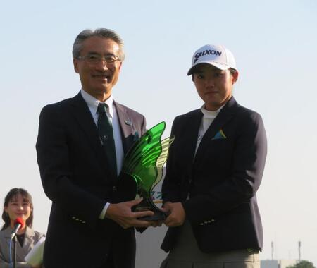 　明治安田の永島英器社長（左）から優勝盾を贈られる岩永杏奈