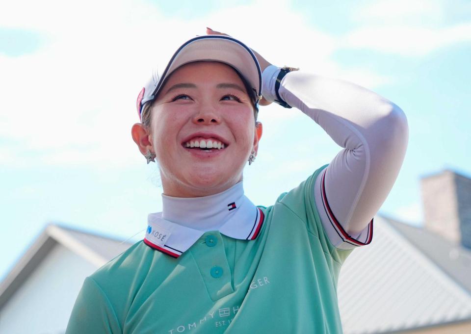 　ホールアウト後、記者の質問に笑顔で答える吉田優利（共同）