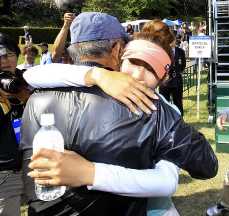 　応援に駆けつけた父・弘吉さんと抱き合い喜びを分かつ金田久美子（右）＝２０１１年