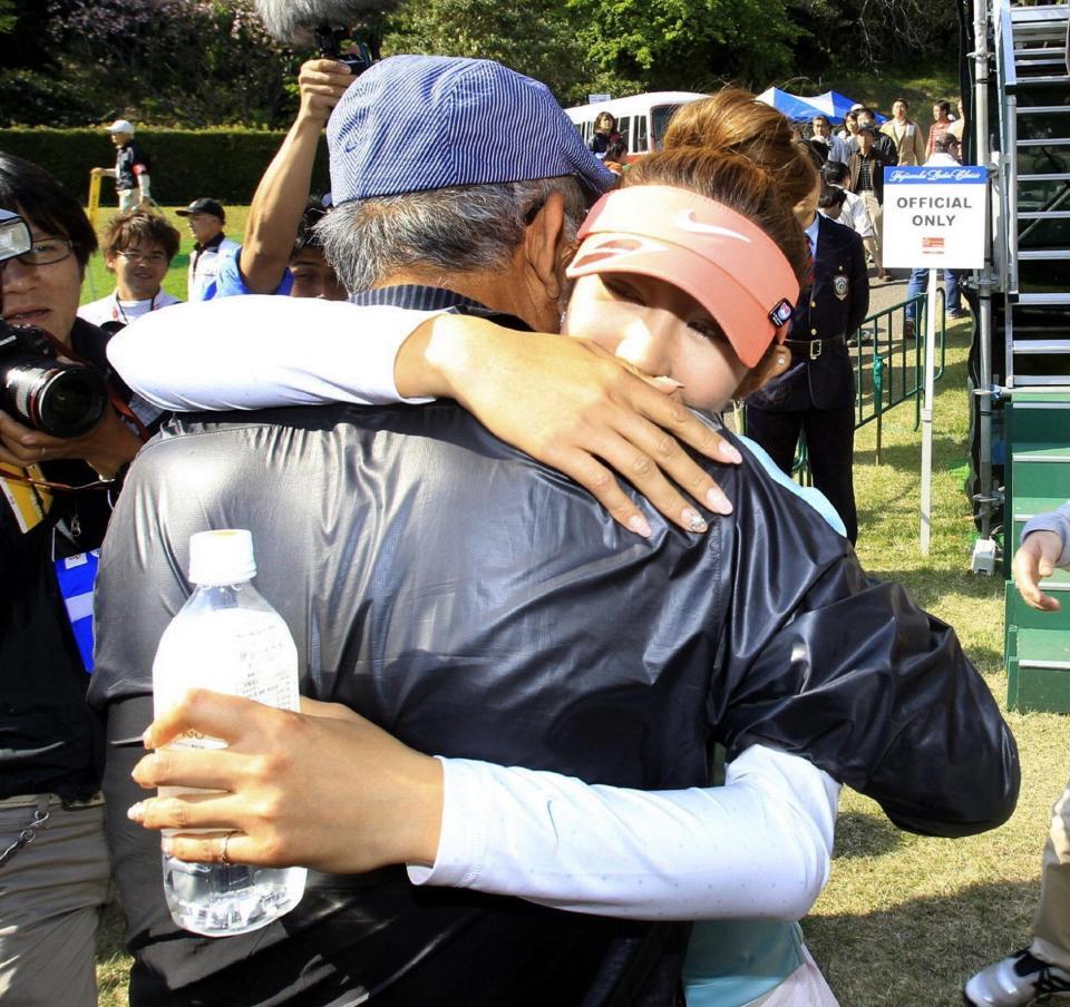 　応援に駆けつけた父・弘吉さんと抱き合い喜びを分かつ金田久美子（右）＝２０１１年