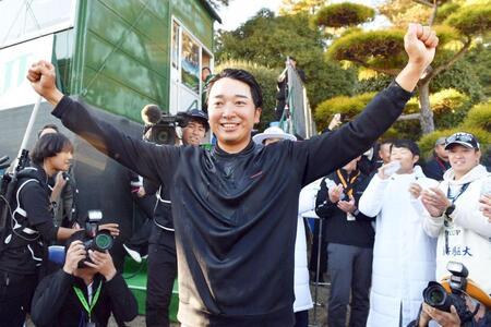 　祝福のウオーターシャワーを浴びてガッツポーズを決める小木曽喬（撮影・開出牧）