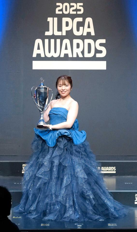 　ドレス姿でトロフィーを手にする佐久間朱莉