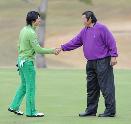 　尾崎将司さん（右）と握手を交わす石川遼＝２００９年