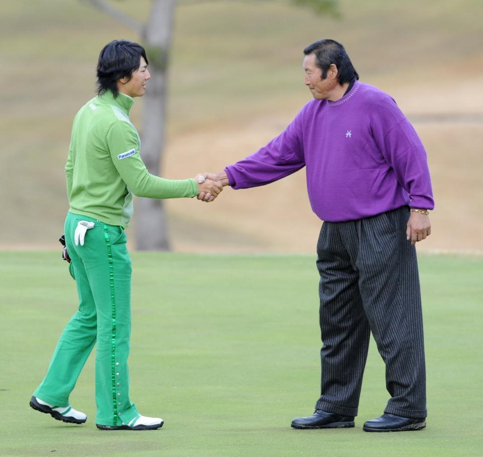 　尾崎将司さん（右）と握手を交わす石川遼＝２００９年