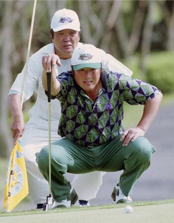 　佐野木キャディーと慎重にラインを読む尾崎将司さん＝００年４月