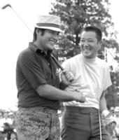 　青木功（右）と笑顔でラウンドする尾崎将司さん＝７４年