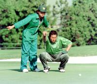 　キャディーを務める長男・智春氏（左）と尾崎将司さん＝９４年