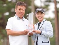 キャディーを務めた父清也さん（左）とトロフィーを手に笑顔を見せる笠りつ子　