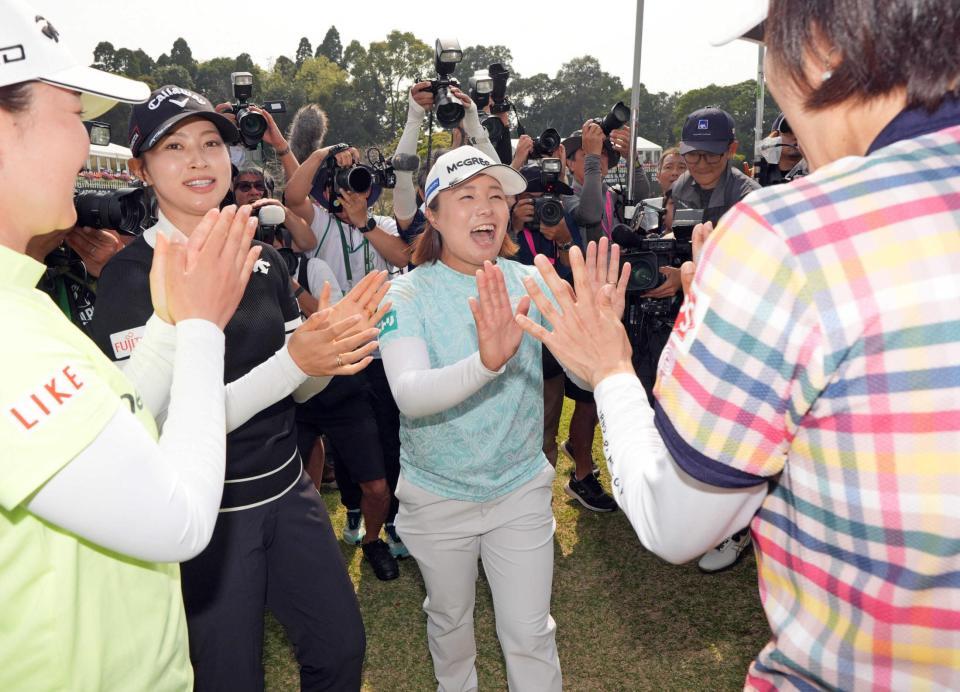 　ホールアウト後、仲間から祝福を受ける永峰咲希（中央）