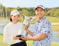 　ツアー初優勝を果たし、トロフィーを手にする石坂友宏と妻の星空さん（撮影・野村和宏）