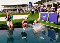 ２大会ぶり２度目の優勝を果たし、18番グリーン脇に造られた小型プールに飛び込むネリー・コルダ（中央）＝メモリアルパーク・コース（共同）