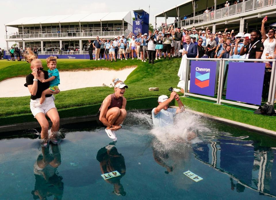 ２大会ぶり２度目の優勝を果たし、18番グリーン脇に造られた小型プールに飛び込むネリー・コルダ（中央）＝メモリアルパーク・コース（共同）